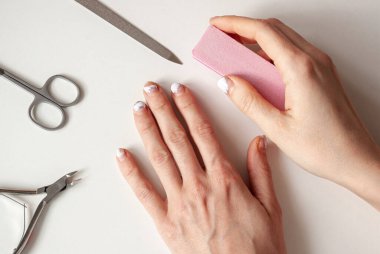 Eski manikür ve tırnak törpüsüyle karantinaya alınmış bir kız. Manikür yaparız, evde kalırız. Soyulmuş, pejmürde jel cilası..