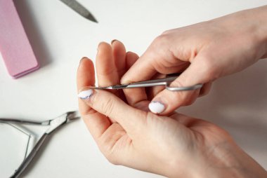 Eski manikürlü bir kızın elleri. Karantinada makasla manikür yaparız. Evde kal. Soyulmuş, pejmürde jel cilası..