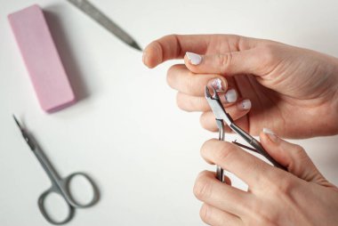 Eski manikürlü bir kızın elleri. Kendimizi karantinada Japonlarla manikür yaparız. Evde kal. Soyulmuş, pejmürde jel cilası..