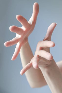 Soluk mavi arka planda narin kadın elleri.