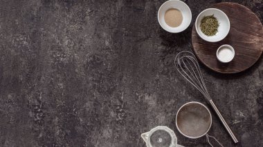 Siyah bir taş masada ev yapımı ekmek pişirmek için gerekli malzemeler. Metin ve tarif için metin boşluğu.