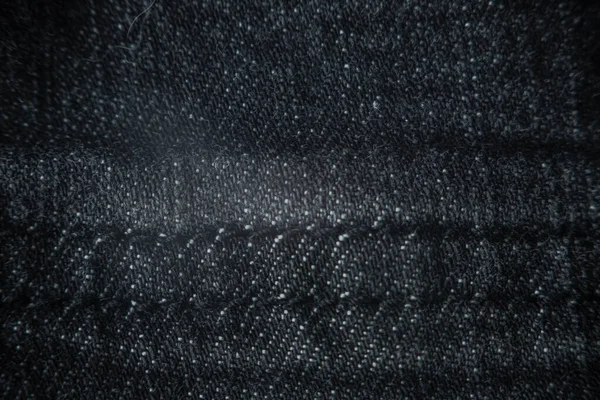 Macro texture of dark gray denim pants. Details textile, fabric, selective focus.