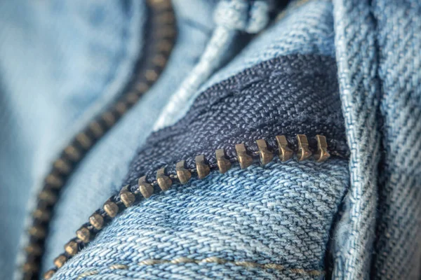 Mavi kot pantolon fermuarı açık, yakın plan. Ayrıntılar tekstil, kumaş, seçici odak.