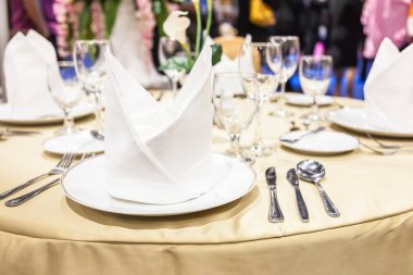 Tabaklara katlanmış beyaz peçeteleri masaya koyun.