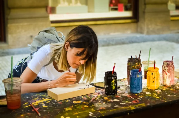 Blonde girl painting in the street