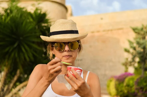 アイスクリームを味わう藁帽子とサングラスを持つ若い女性 — ストック写真