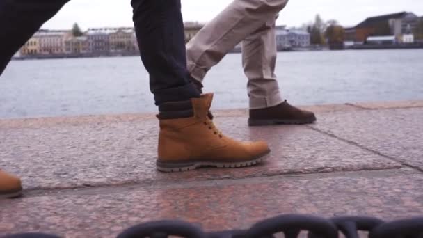 Turistas caminhando sapatos de pé na beira de um penhasco ao longo do rio com corrente — Vídeo de Stock