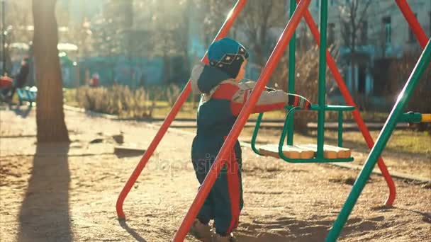 Lachen van de kleine jongen rijden op een schommel — Stockvideo