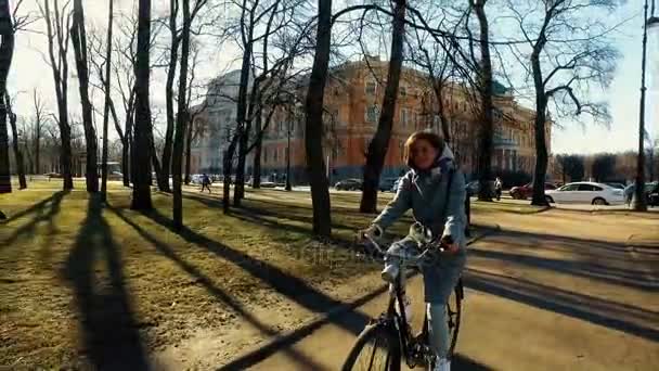 Young beautiful woman riding a bicycle in a park. Active people. Outdoors — Stock Video