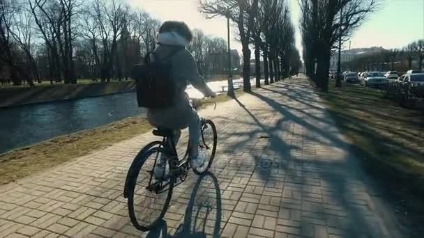 Jovem bela mulher montando uma bicicleta em um parque. Pessoas activas. Ao ar livre — Vídeo de Stock