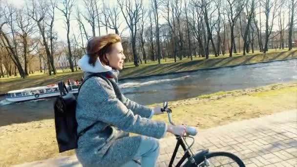 Joven hermosa mujer montando una bicicleta en un parque. Gente activa. Al aire libre — Vídeos de Stock