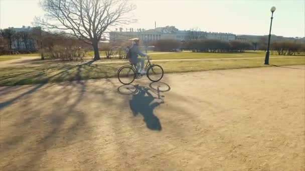 Young beautiful woman riding a bicycle in a park. Active people. Outdoors — Stock Video