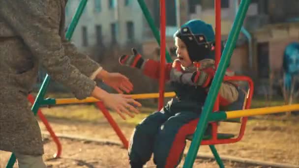 Gülen küçük çocuk salıncakta sürme — Stok video