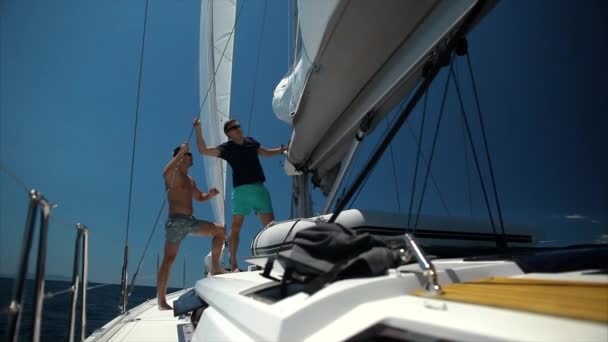 Två stiliga män segling på en lyxig yacht. — Stockvideo