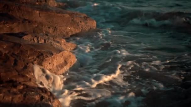 Gros plan sur les rochers marins et les vagues le soir 