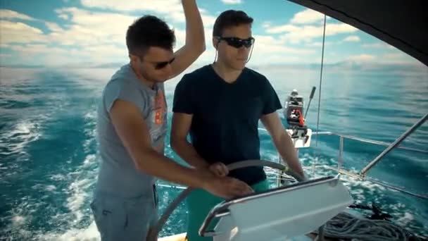 Twee jonge mannen in zee op de luxejacht zeilen — Stockvideo