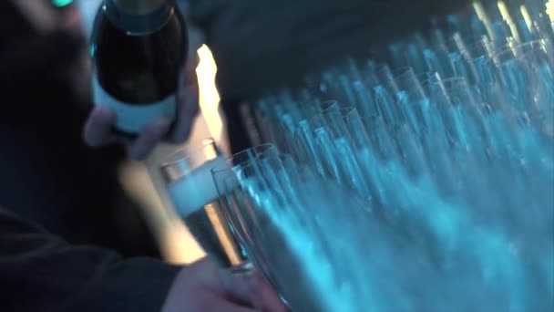 O garçom derrama champanhe em um copo em celebração — Vídeo de Stock
