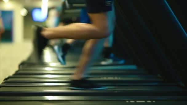 Manliga ben i sneakers kör på en orbitrek-simulator. — Stockvideo