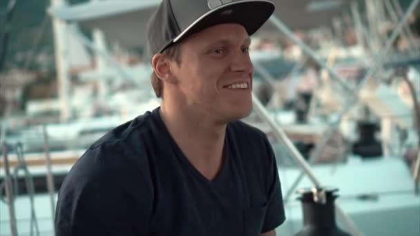 Un jeune homme souriant écoute un ami sur le yacht . — Video