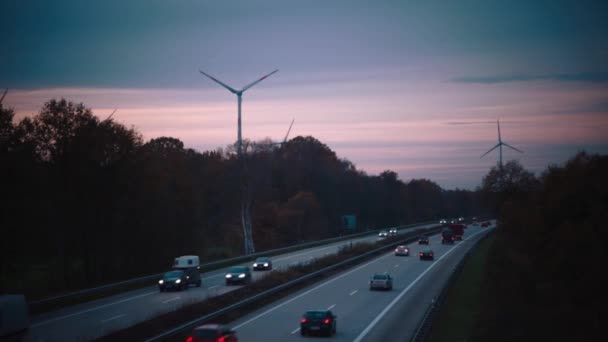 Autobahn och väderkvarnar på elkraft på sunset himmel bakgrund. — Stockvideo