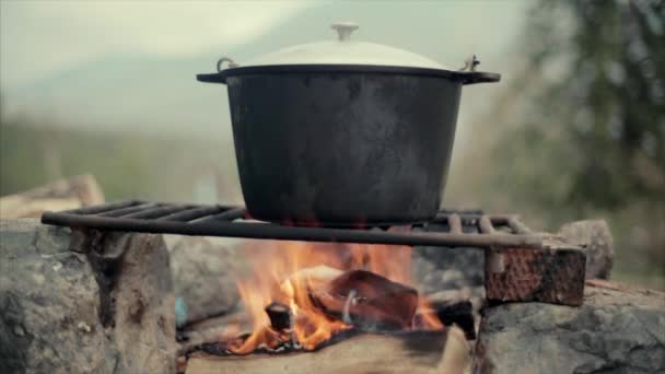 Comida sobre una fogata en el bosque — Vídeos de Stock