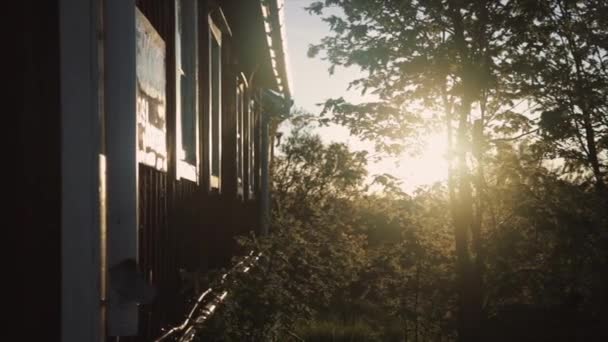 Sonnenuntergang scheint durch die Äste in der Nähe des Hauses — Stockvideo