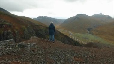 Mutlu uzun yürüyüşe çıkan kimse uzanmış, kollarını ile başarı dağlarda