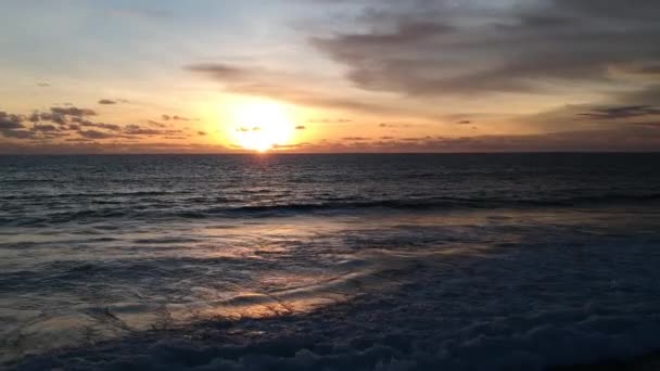 无人机带着日落般的海浪在海面上飞走，人们在这些海浪中 — 图库视频影像