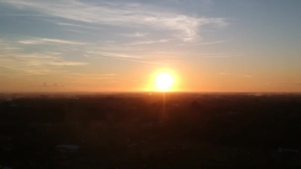 Όμορφο ηλιοβασίλεμα, και ένα φωτεινό κύκλο του ήλιου ενάντια σε ένα μπλε-πορτοκαλί ουρανό με γραφικά σύννεφα cirrus — Αρχείο Βίντεο