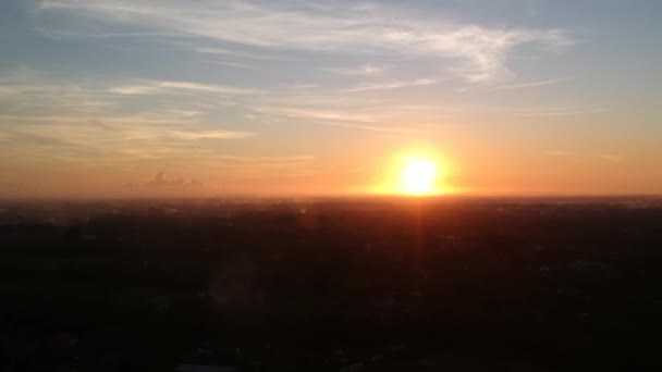 Una hermosa puesta de sol con un dron despegando, un círculo brillante del sol es visible contra un cielo azul-naranja con pintorescas nubes de cirros — Vídeos de Stock