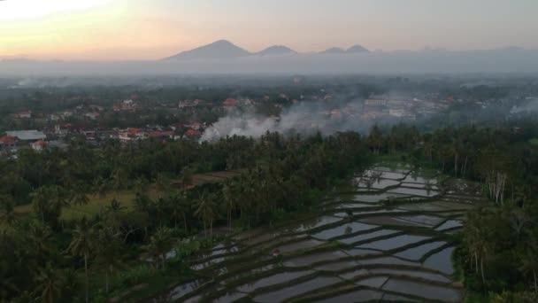 Prachtige zonsondergang met quadrocopter dolly over rijstterrassen met reflectie van water, bergen aan de horizon en een ballon met pittoreske wolken en blauwe lucht in Ubud Bali — Stockvideo