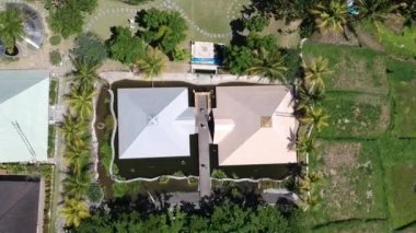 İnsansız hava aracı, Ubud Bali 'de suyla çevrili piramitlerin üzerine iniyor. İnsanlar açık güneşli havada piramitlere giriyor.