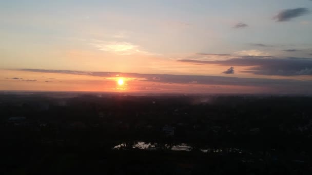 Décollage au coucher du soleil sur un ubud lors d'un coucher de soleil pittoresque, à une grande hauteur, le cercle rouge du soleil est visible à travers les nuages — Video