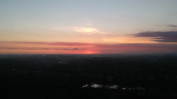 Απογείωση προς το ηλιοβασίλεμα πάνω από ubud κατά τη διάρκεια ενός γραφικού ηλιοβασιλέματος, σε μεγάλο ύψος, ο κόκκινος κύκλος του ήλιου είναι ορατός μέσα από τα σύννεφα — Αρχείο Βίντεο