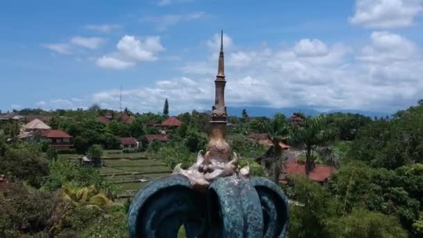 Aterrizaje en Ubud en tiempo soleado contra un techo con una aguja — Vídeos de Stock