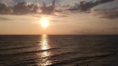 İnsansız hava aracı gün batımında kıyıya yakın insanların arka planında patladı.