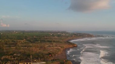 Pura Tanah 'ın yanından Canggu bölgesine yaklaşıyoruz. Gün batımında görünen dalgalar ve yeşil açıklıklar.