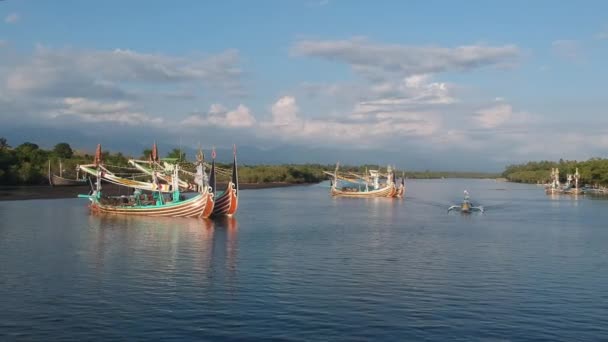 Drone benadering van grote en mooie Balinese boten en een kleine boot drijft in Prancak Perancak west bali — Stockvideo