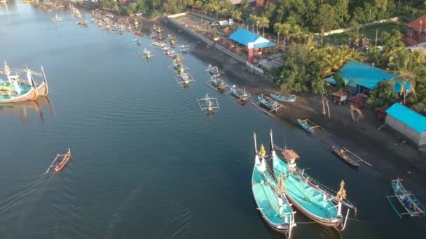 Muchos barcos balineses tradicionales en el fondo del puerto y pequeños barcos en el océano Prancak Perancak oeste bali — Vídeos de Stock