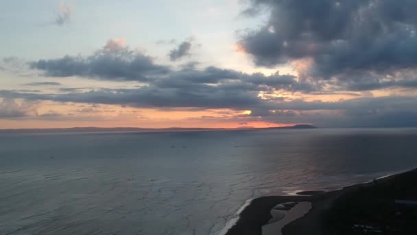 Timelapse menurun pada pesawat tak berawak di atas laut di mana kapal berlayar untuk matahari terbenam dan banyak awan Prancak Perancak Peninsula — Stok Video