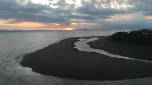 Un vuelo con drones sobre el océano durante el atardecer Prancak Península de Perancak costa visible de la isla y barcos de pesca en la distancia — Vídeos de Stock