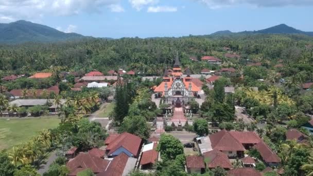 Drone aproximando-se Sagrado Coração de Jesus Igreja Católica oeste bali indonésia contra o pano de fundo da selva e montanhas em tempo ensolarado — Vídeo de Stock