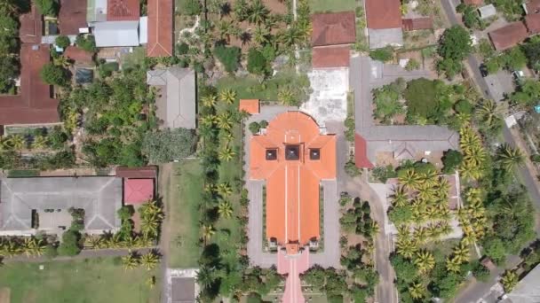 Despegar en lo alto de un dron Sagrado Corazón de Jesús Iglesia Católica oeste bali indonesia techo naranja visible del templo en forma de cruz — Vídeos de Stock