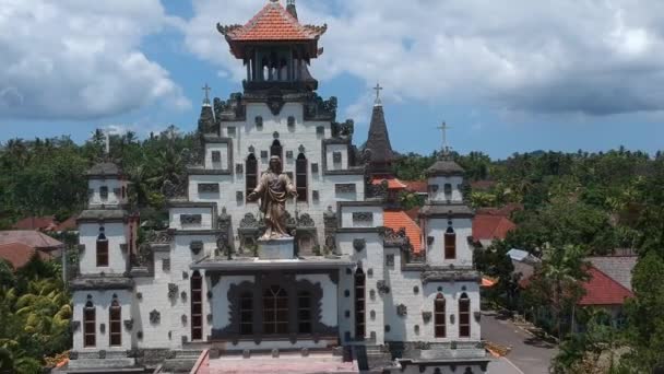 The departure from the statue of Jesus Sacred Heart of Jesus Catholic Church west bali indonesia and the distance away the jungle and mountains appear far — Stock Video