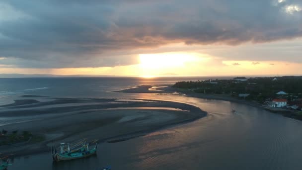 Безпілотний літальний апарат летить до епічного заходу сонця в гавані півострова Пранкак Перанкак Балі Індонезії один плавучий риболовецький човен видно — стокове відео