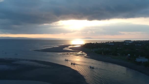 Lot dronem nad portem, gdzie łodzie przekraczają ścieżkę światła słonecznego o zachodzie słońca Półwysep Pranchak Peranchak — Wideo stockowe