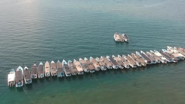 在阳光明媚的蓝水背景下，无人驾驶飞机飞越了一群彼此相连的蓝色渔船。在阳光明媚的天气里，罗本 · 拉朗美纽兹 · 努萨拜 · 门江 — 图库视频影像