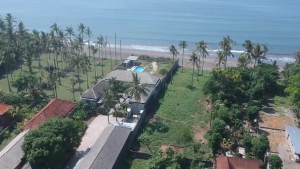 Vuelo de drones sobre un edificio de techo gris océano península de Prancak en tiempo soleado península de Perancak oeste bali indonesia — Vídeos de Stock