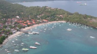 Padang Bai limanından ayrılan küçük balıkçı tekneleri ve uzaktaki birkaç büyük taşıyıcı Bali Endonezya görünür