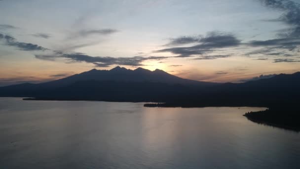 Взлет на фоне вулкана на острове Ломбок Пулау Ломбок Западная Нуса Тенггара на рассвете рыбацкие лодки видны — стоковое видео